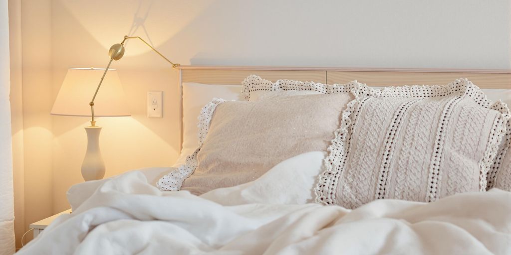 Cozy bedroom with soft lighting and inviting bedding.