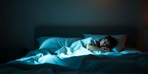 Cozy bedroom, soft lighting, person sleeping peacefully.